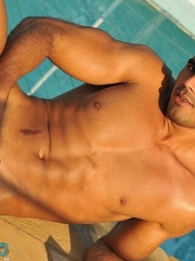 Handsome athlete Poax strips by the poolside